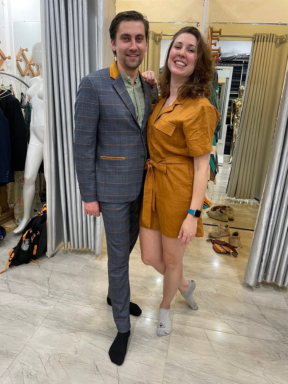 A customer in a grey windowpane-check suit with tan accents at the shop