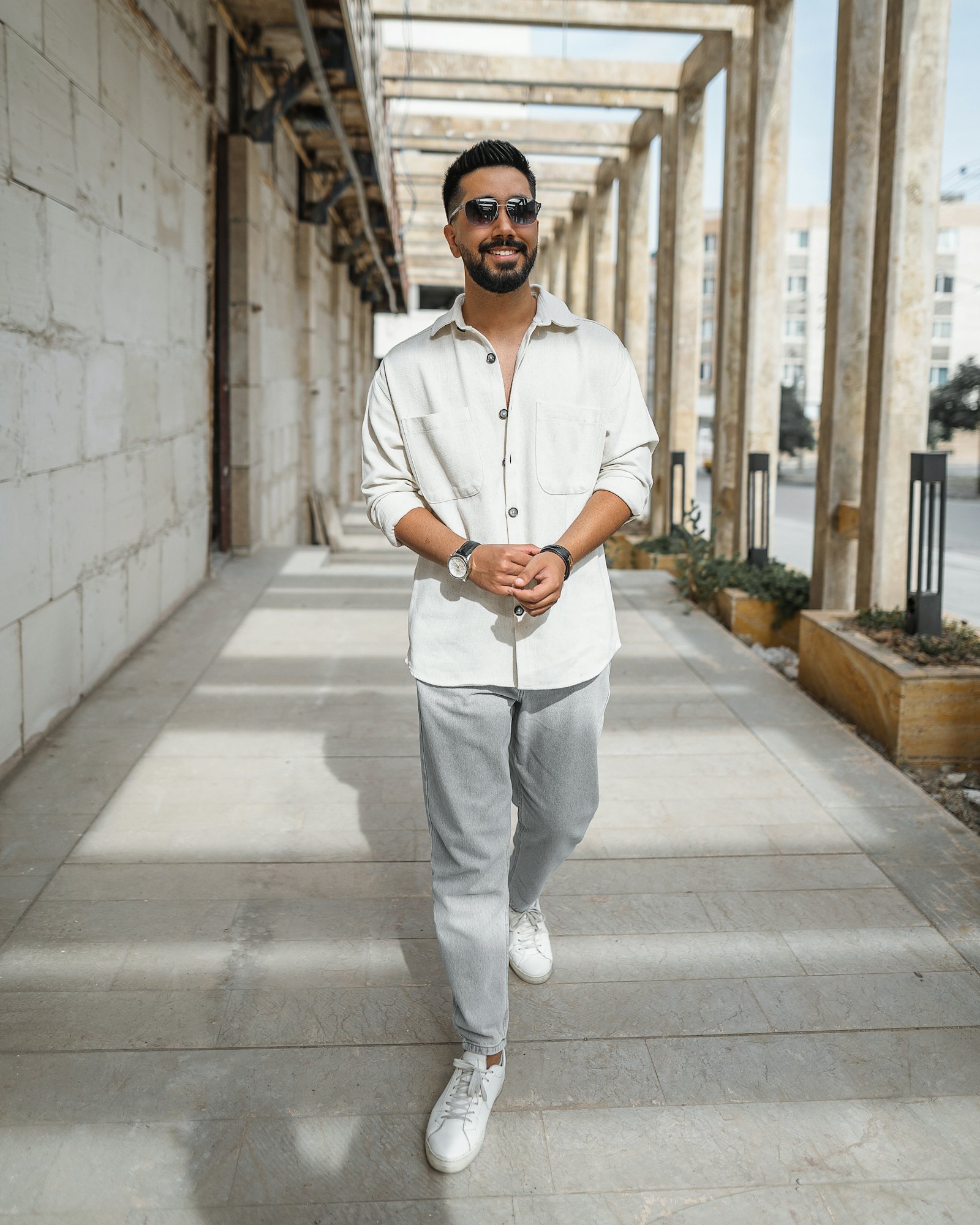 Man in an off-white linen overshirt with light grey trousers