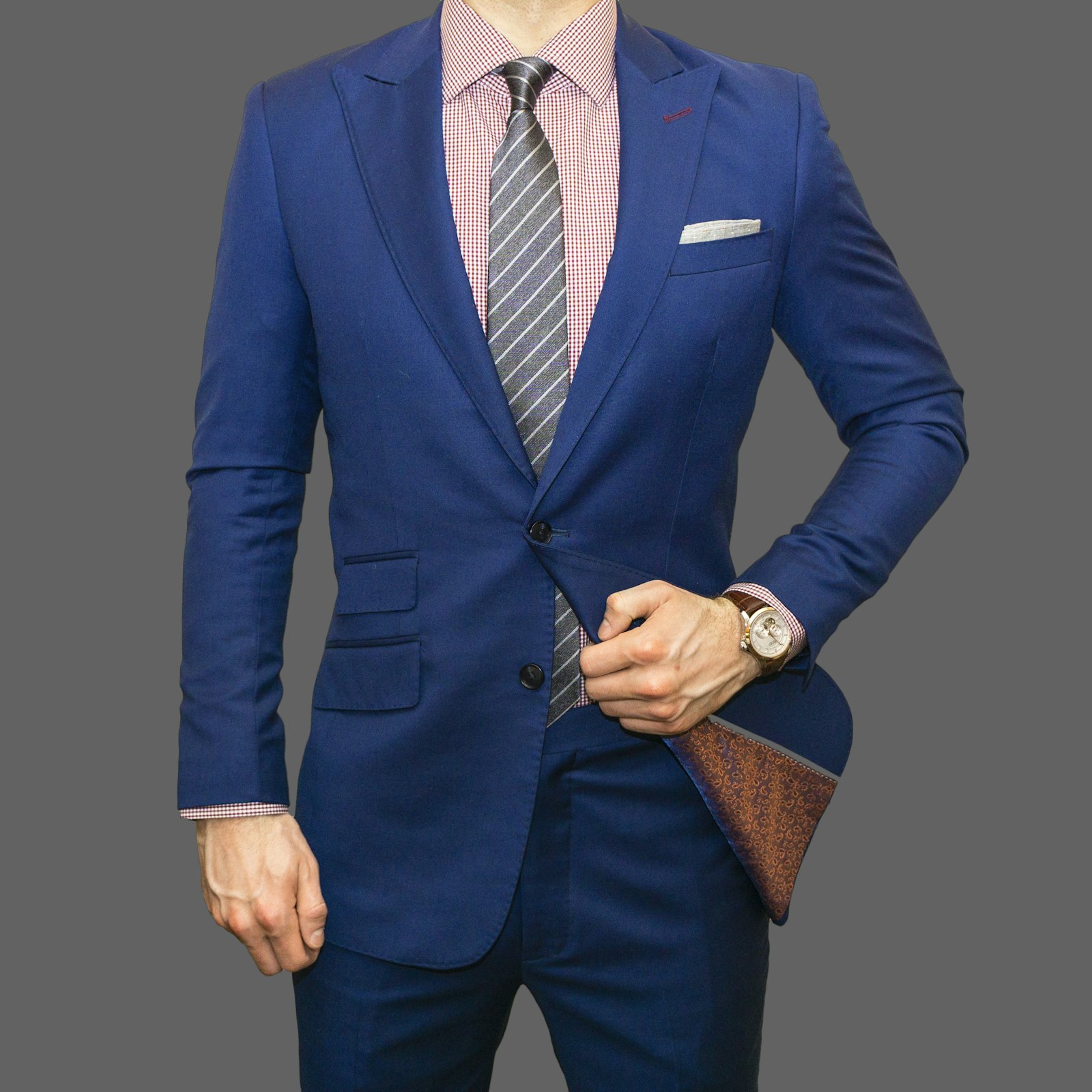 Detail of a navy wool jacket with peak lapel and patch pocket
